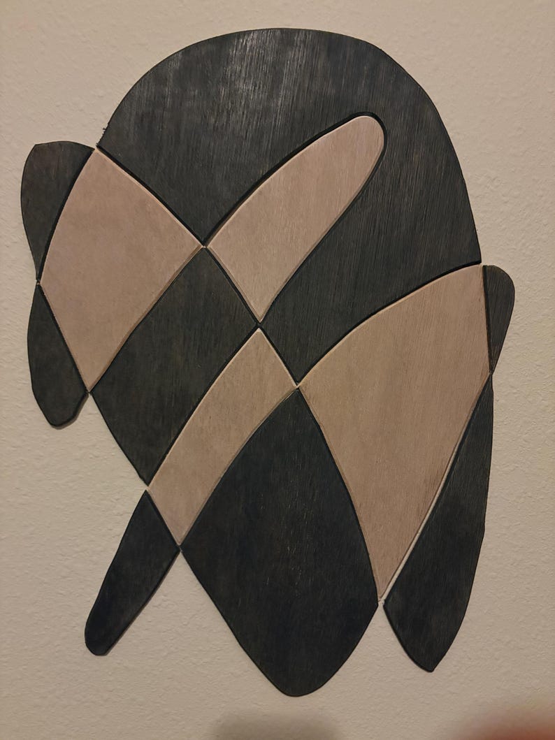 Wall piece in near-black and pale natural wood