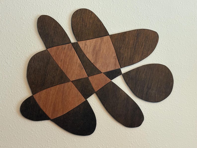 Landscape wall piece of rounded petal shapes in dark brown with copper-toned center sections
